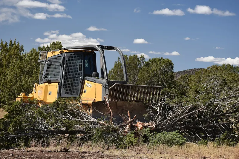 A dozer pushing cut trees into piles to be burned, hauled or ground later.